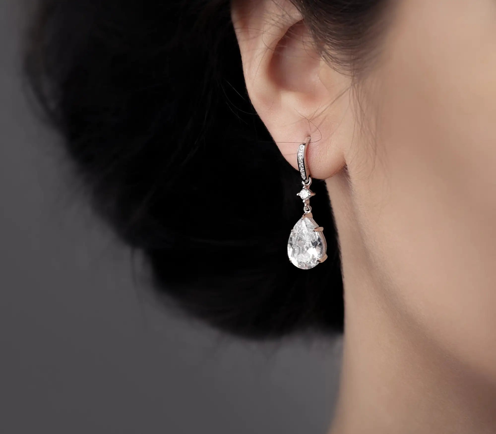 Elegant teardrop-shaped diamond earring in rose gold with a pave-set top and delicate chain.