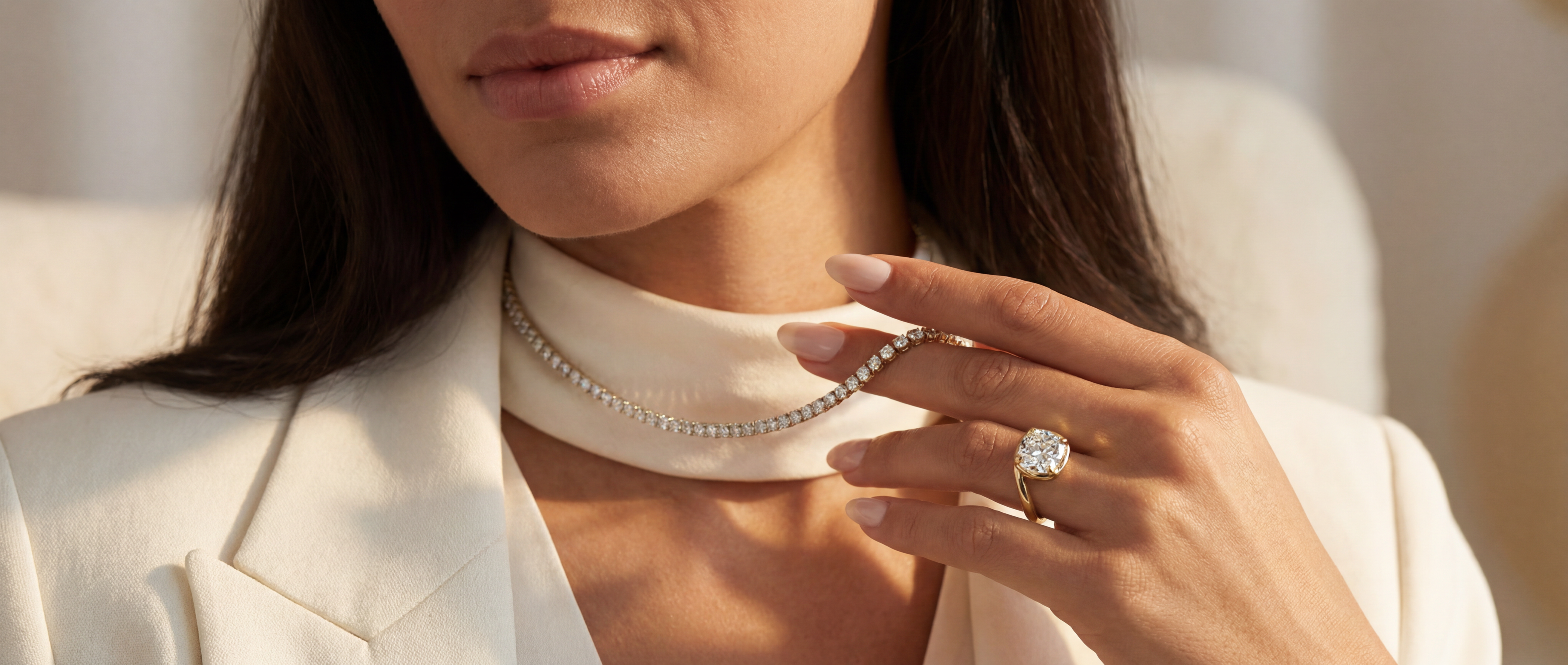 Close-up of a woman wearing a pearl necklace and ring, with a blurred background.