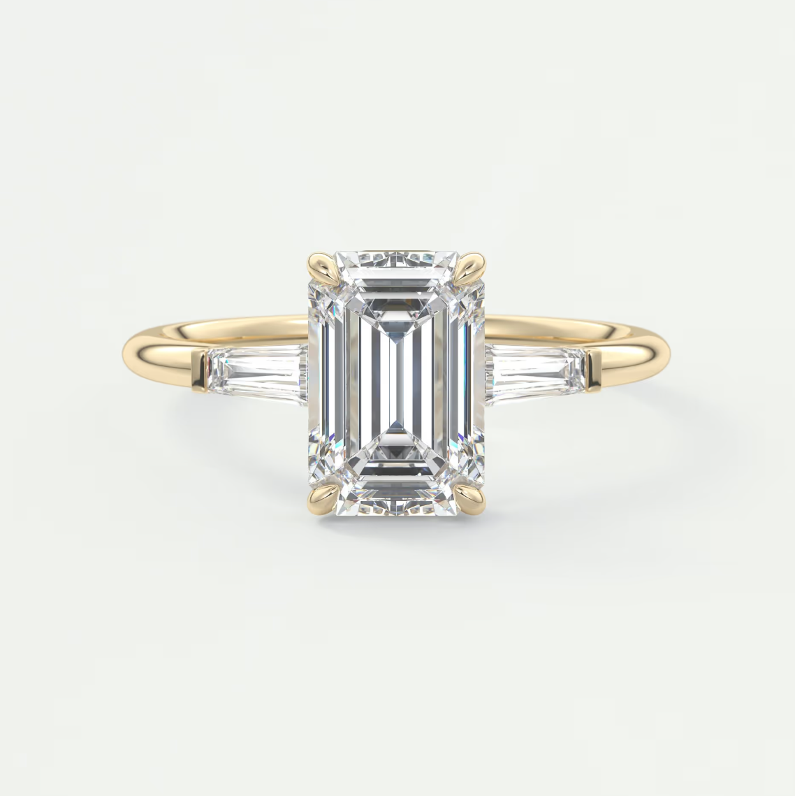 Custom made elysian emerald three-stone engagement ring with tapered baguettes