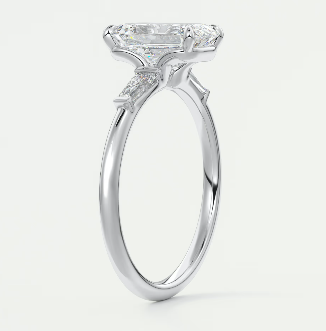 Custom made elysian emerald three-stone engagement ring with tapered baguettes