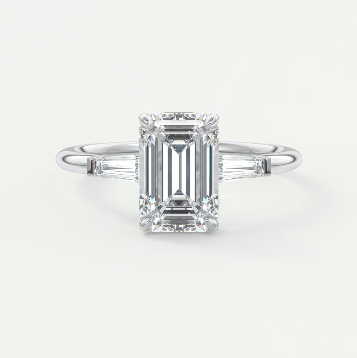 Custom made elysian emerald three-stone engagement ring with tapered baguettes