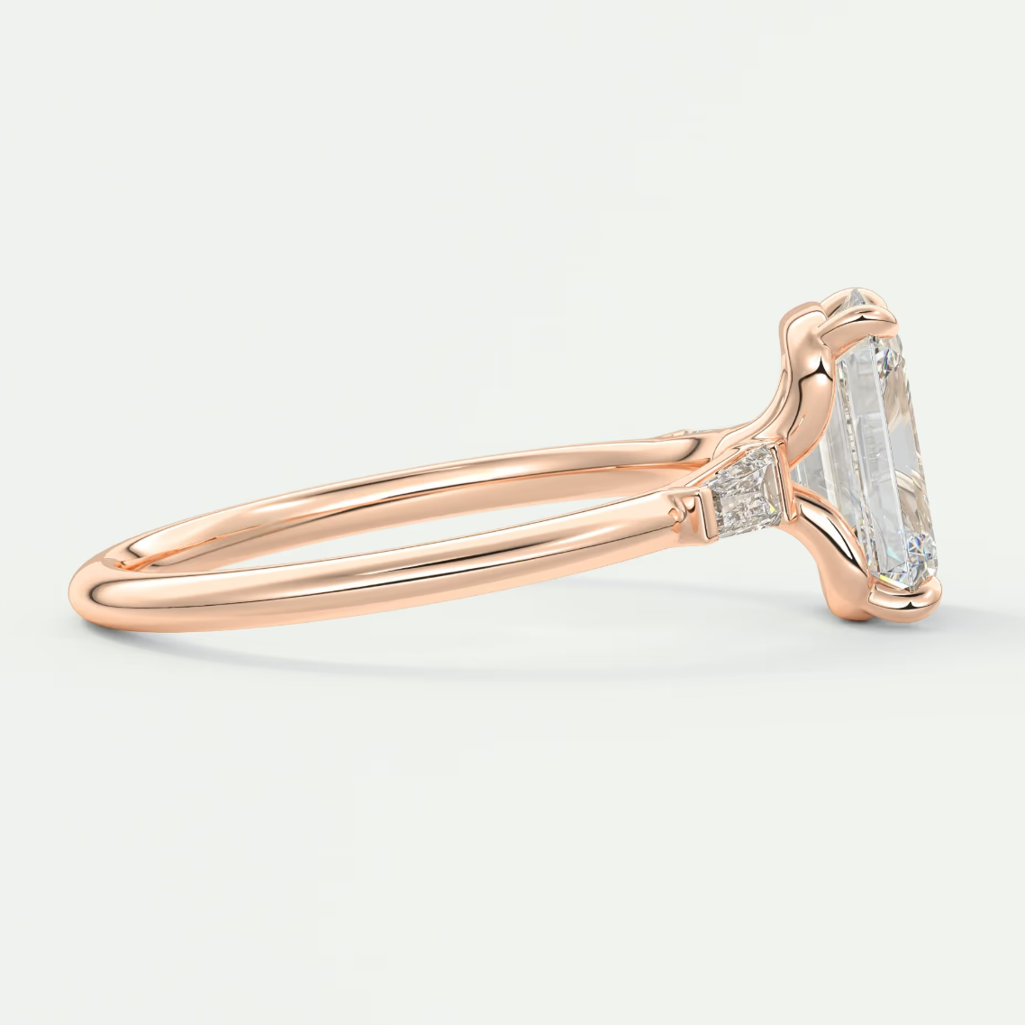 Custom made elysian emerald three-stone engagement ring with tapered baguettes