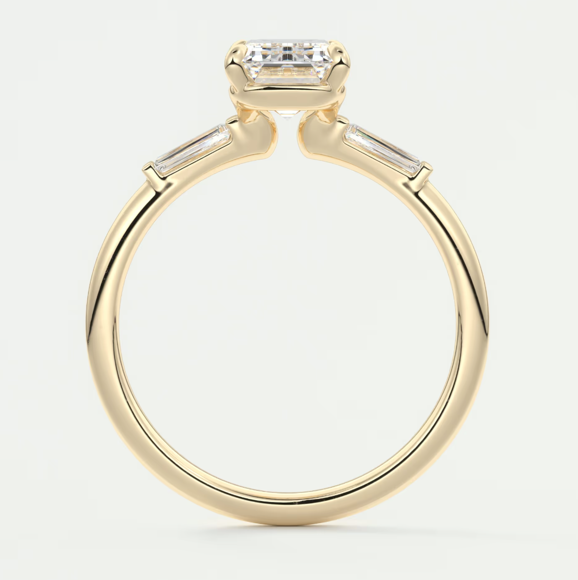 Custom made elysian emerald three-stone engagement ring with tapered baguettes