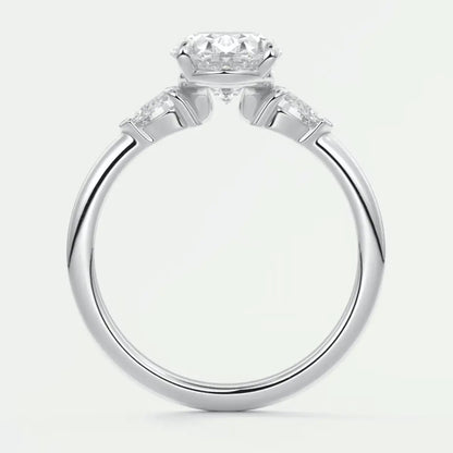 18k white gold engagement ring with a round diamond center stone and two smaller diamonds on each side.