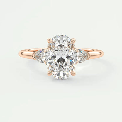18k rose gold diamond engagement ring with an oval center stone and pear-shaped side stones.
