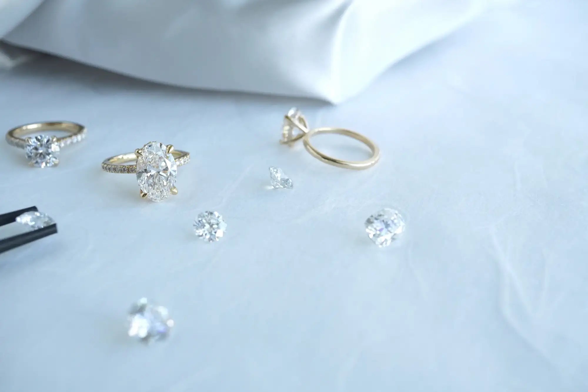 Gold and silver jewelry including rings and earrings on a white surface.