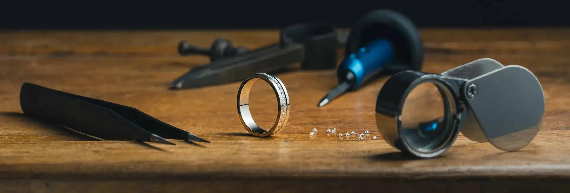Gold ring with jewelry tools on a wooden surface