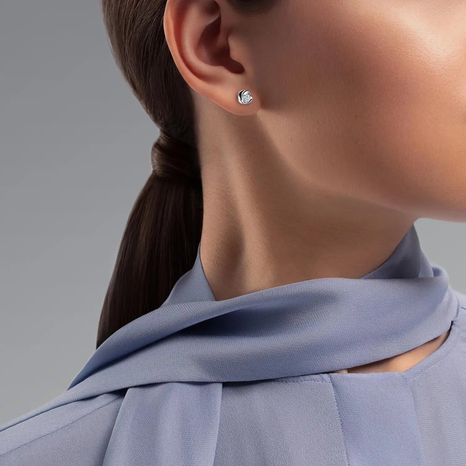 A sleek, minimalist stud earring featuring a single round brilliant-cut diamond set in polished white gold.