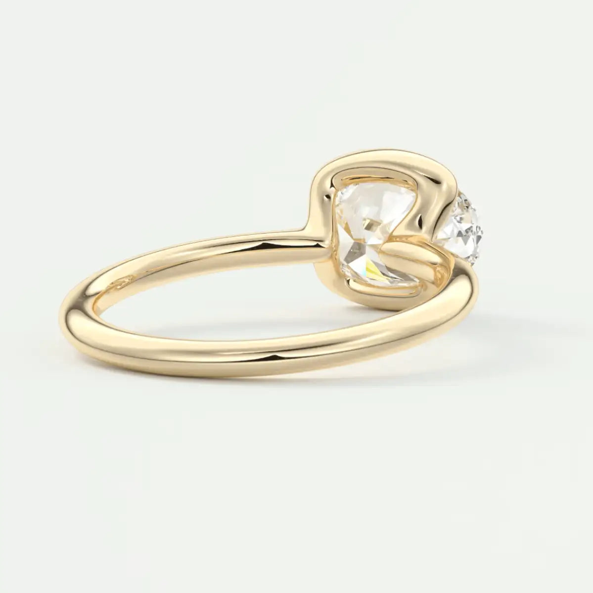 Gold heart-shaped diamond engagement ring with a single smaller stone on the side.