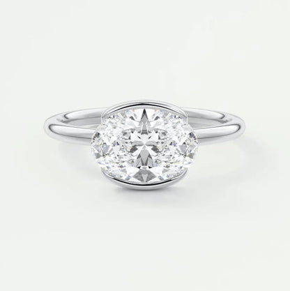 18-karat white gold oval diamond engagement ring with a bezel setting.