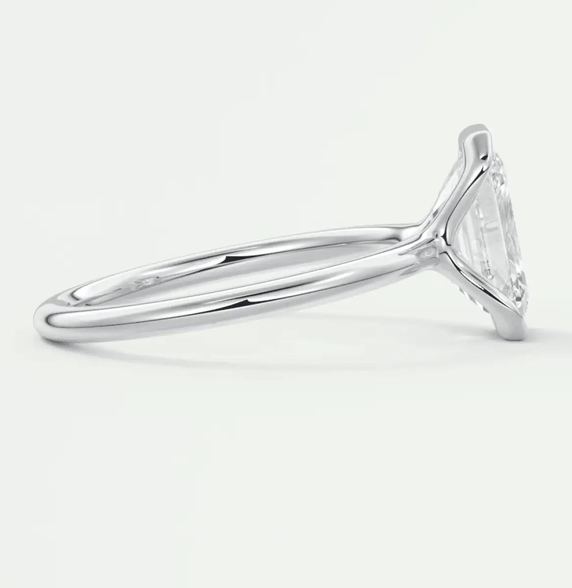 White gold solitaire engagement ring with a marquise-cut diamond.