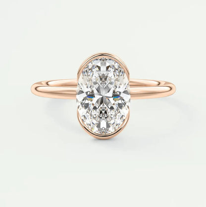 Rose gold oval diamond engagement ring with a bezel setting.