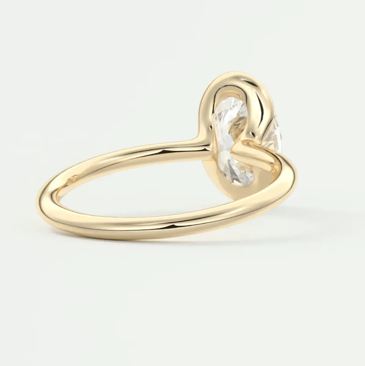 Gold knot ring with a clear gemstone center.