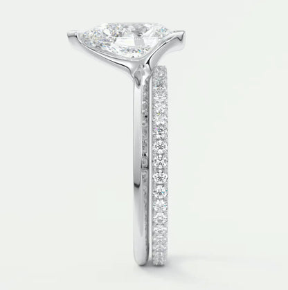 18k white gold diamond engagement ring with a pear-shaped center stone and channel-set side stones.