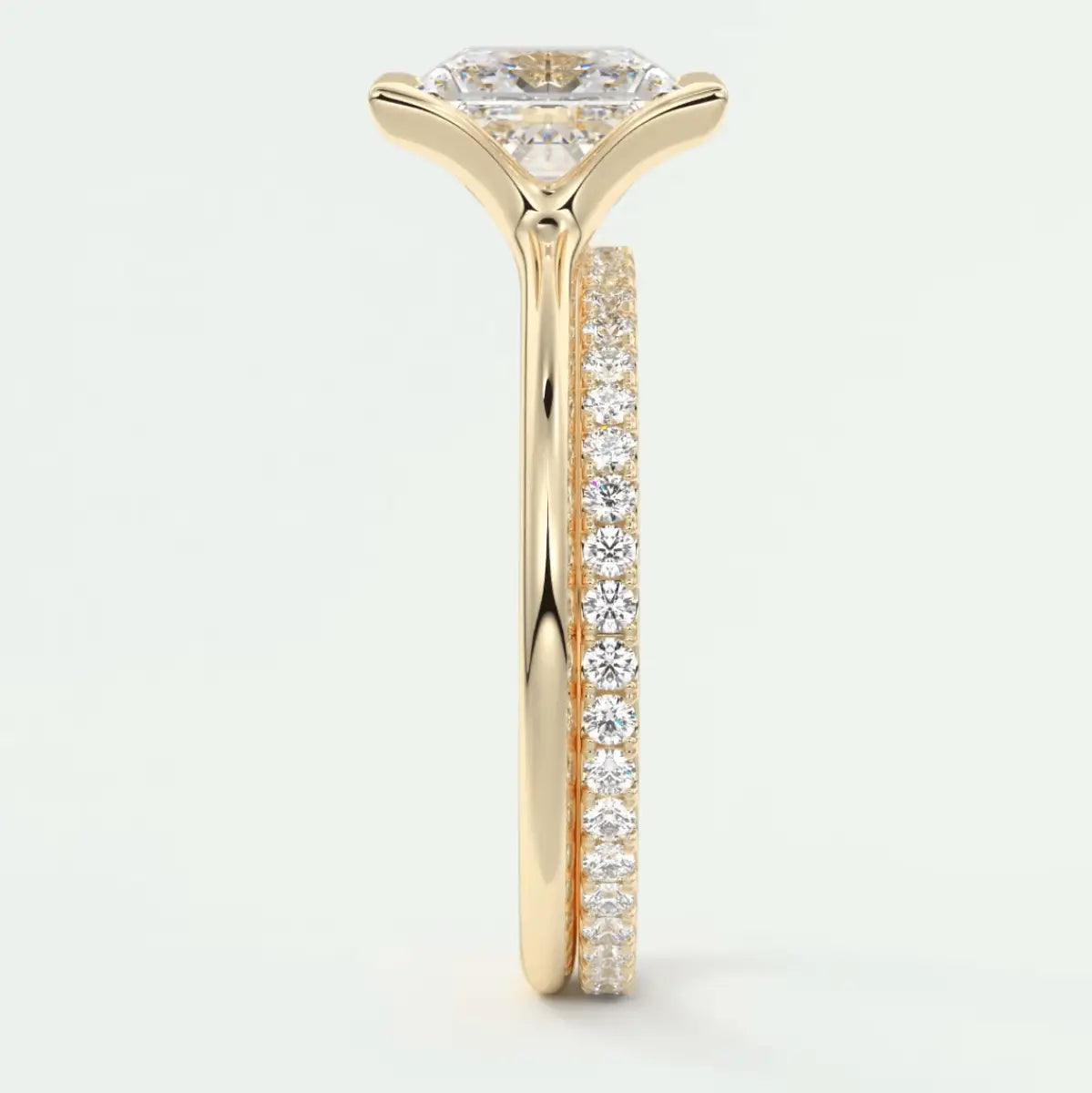 18k yellow gold engagement ring with a round diamond center and pavé side stones.