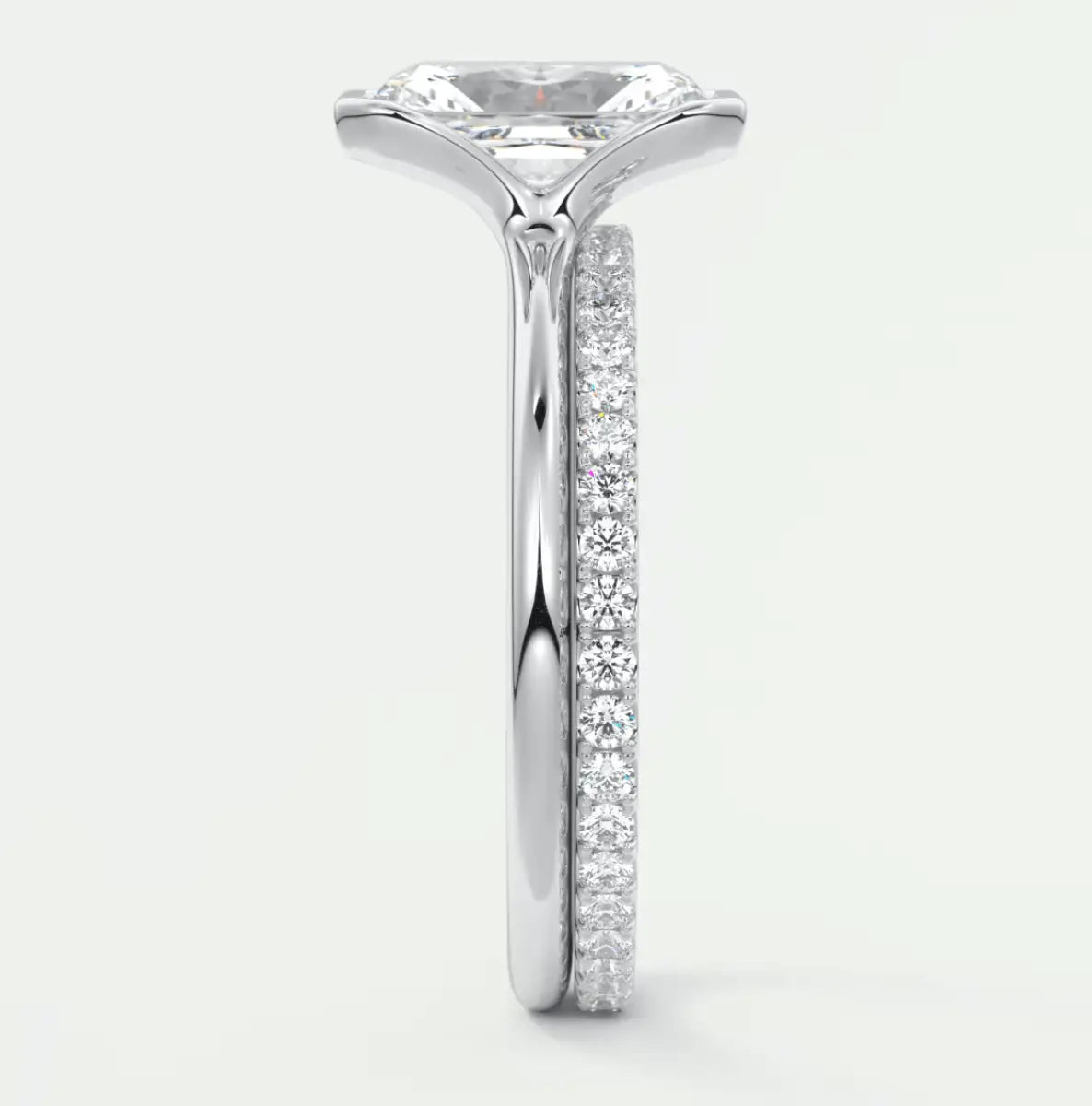 18-karat white gold engagement ring with princess-cut diamond center stone and pave-set diamonds on the band.