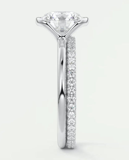 18k white gold engagement ring with a round diamond center and pave set diamonds on the band.