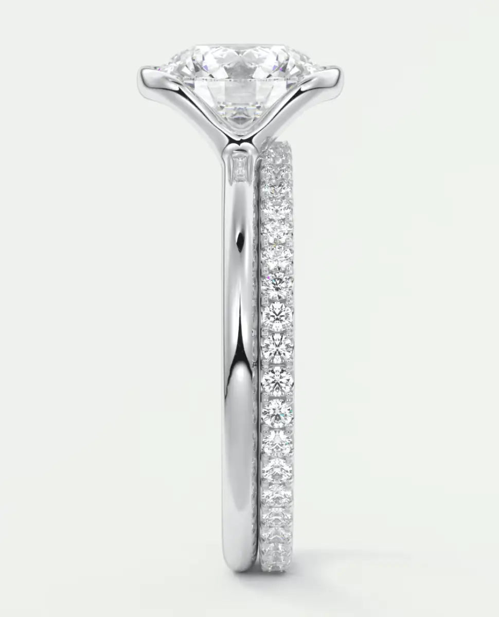 18k white gold engagement ring with a round diamond center and pave set diamonds on the band.