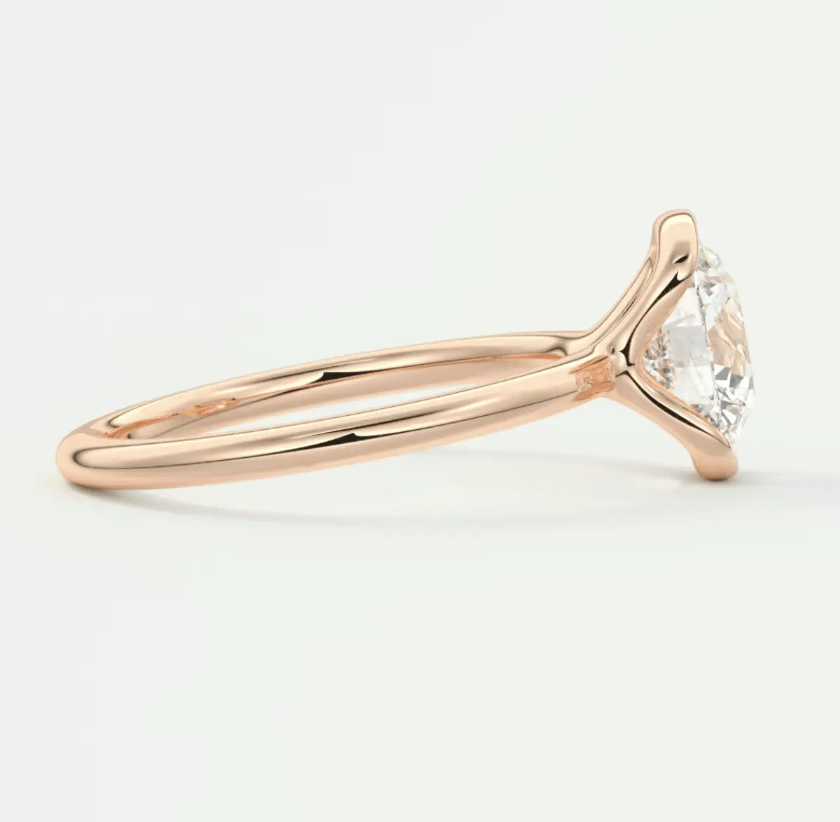 Rose gold engagement ring with a pear-shaped diamond.