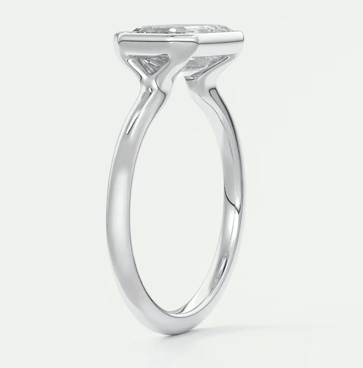 White gold solitaire engagement ring with a cushion-cut diamond.