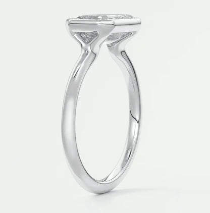 White gold solitaire engagement ring with a cushion-cut diamond.