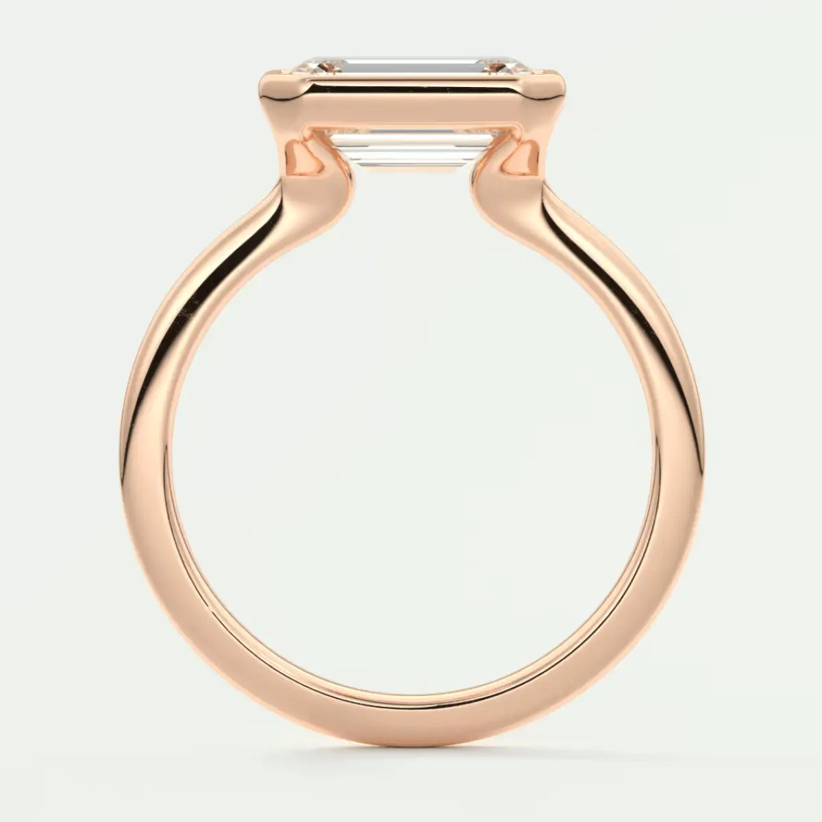 Rose gold emerald cut diamond engagement ring with a sleek, modern design.