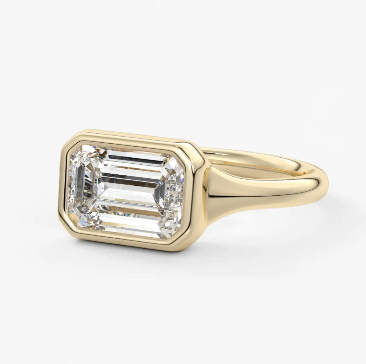 18k yellow gold emerald-cut diamond engagement ring with a bezel setting.