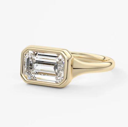 18k yellow gold emerald-cut diamond engagement ring with a bezel setting.