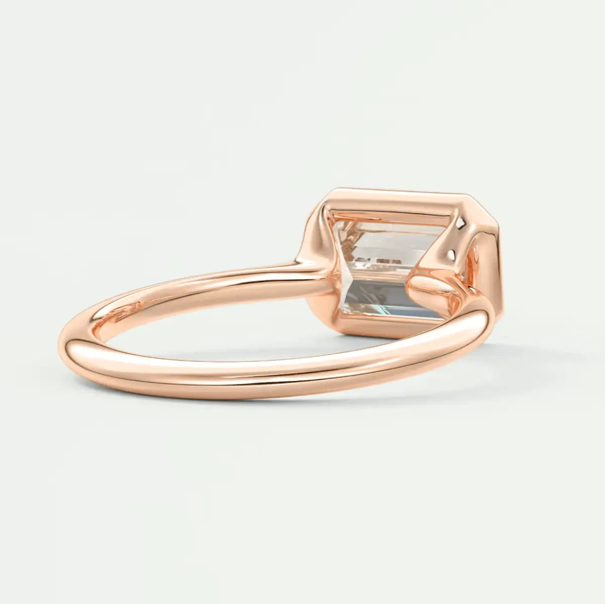 Rose gold emerald-cut gemstone ring with a princess cut diamond accent.