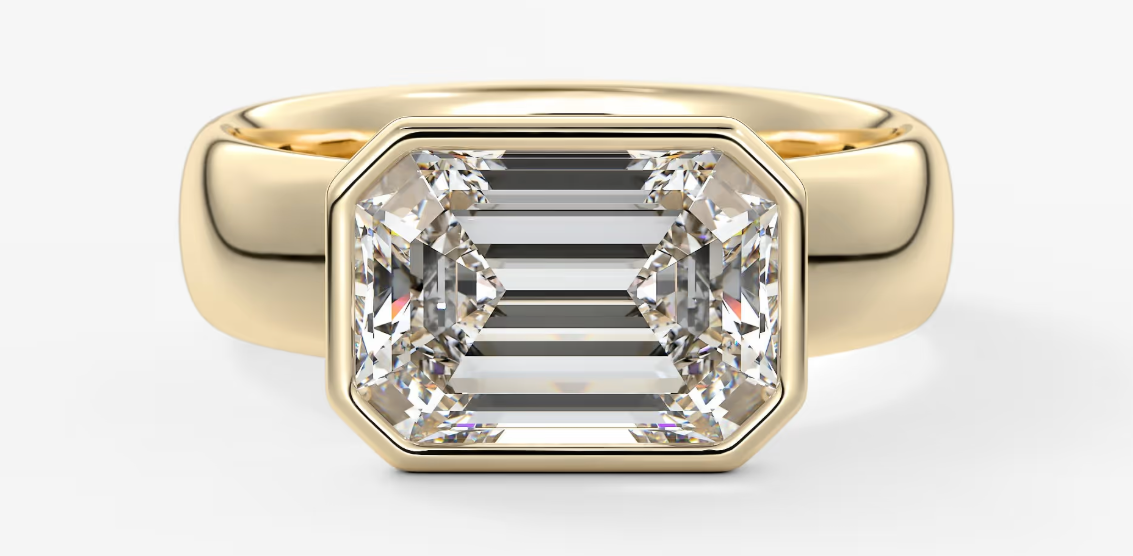 Gold ring with a large diamond on a white background