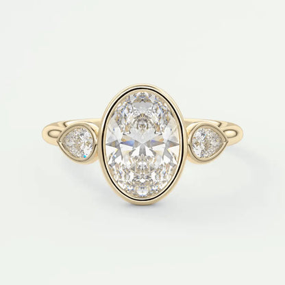 18k yellow gold diamond engagement ring with an oval-cut center stone and two smaller round diamonds.