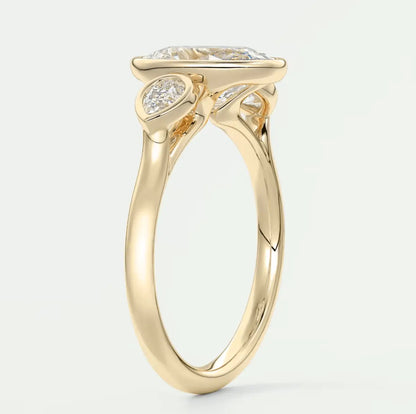 18k yellow gold engagement ring with a princess cut diamond and two smaller diamonds on either side.