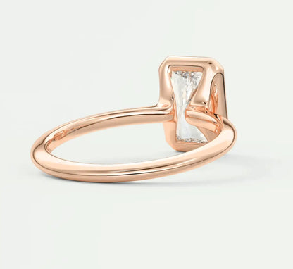18k rose gold diamond engagement ring with a baguette-cut center stone and small side diamonds.